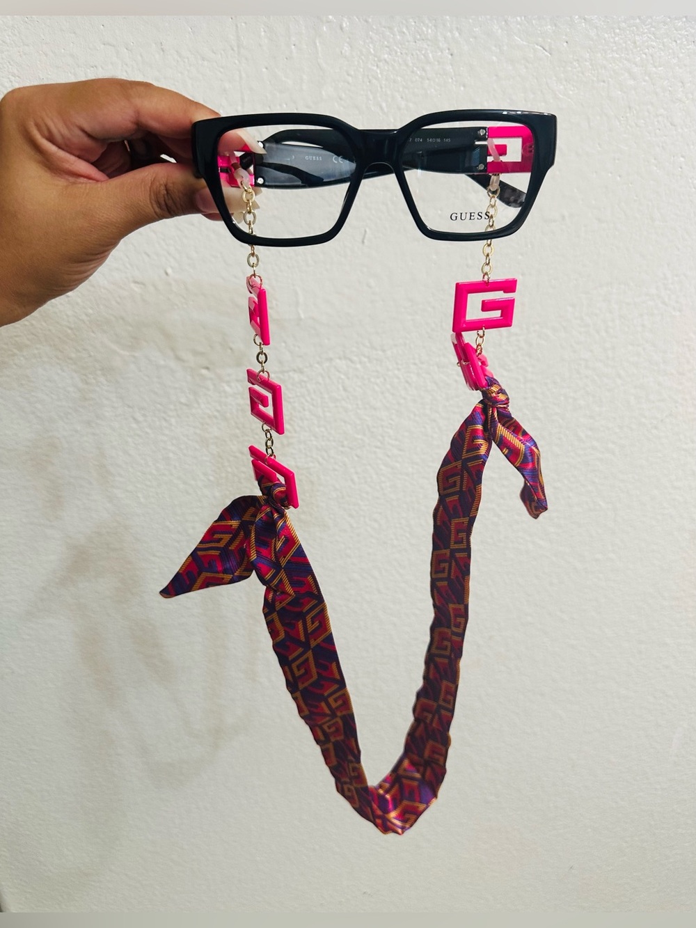 GUESS Black Glasses Chain with Hot Pink Logo Accents and Patterned Ribbon